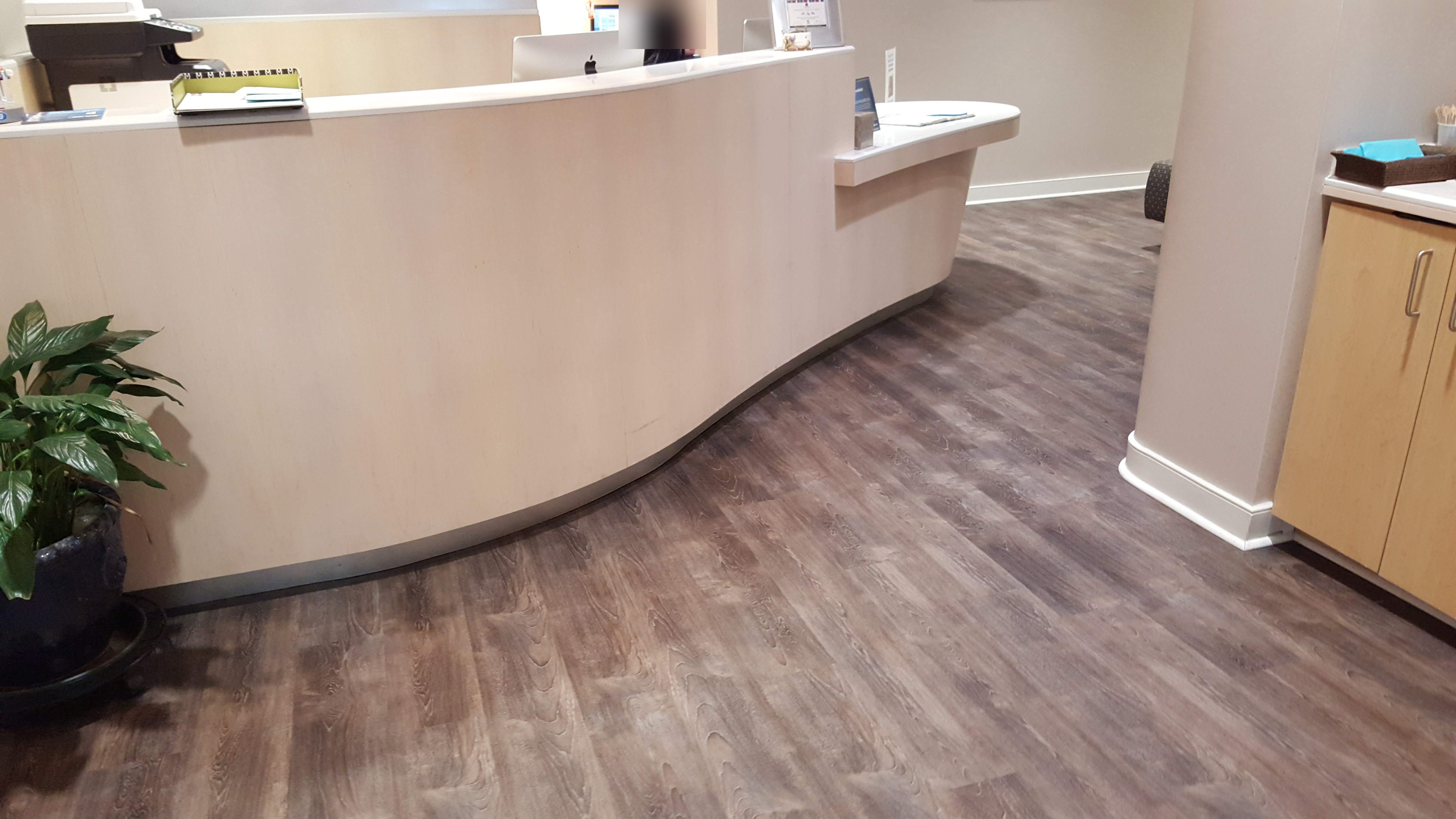 Medical office flooring: wood-look vinyl plank along a curved reception desk