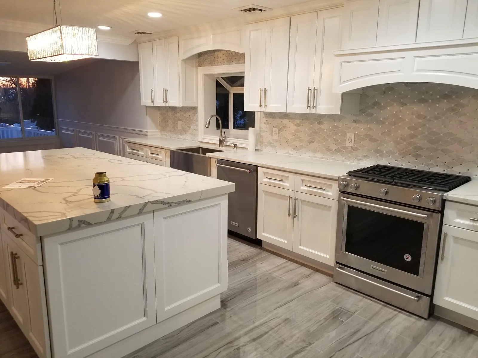 Kitchen remodel in Massapequa, NY: white shaker cabinets, marble-look island and arabesque mosaic backsplash