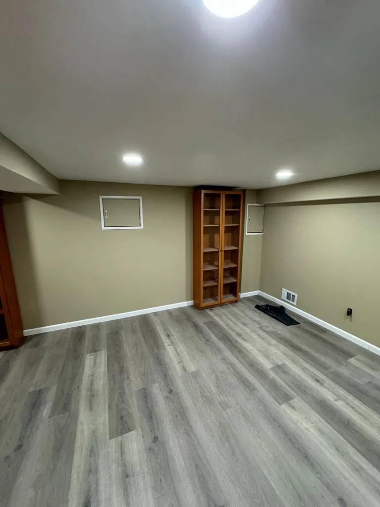 Basement remodel in Oceanside, NY: gray vinyl plank floor and finished walls
