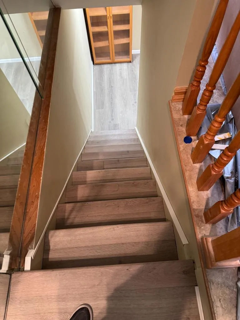 Basement staircase remodel in Oceanside, NY: wood treads seen from the top of the stairs