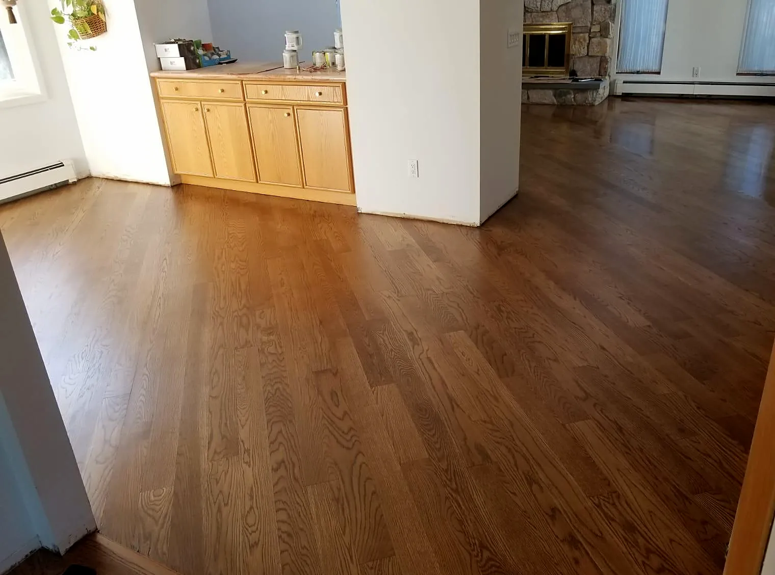 Dining area remodel in Seaford, NY: a refinished golden-brown wood floor in a dining area with a built-in wood cabinet